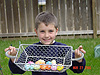 Tyler holding up his temporary basket full of eggs