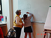 The instructor showing one of the kids how to draw